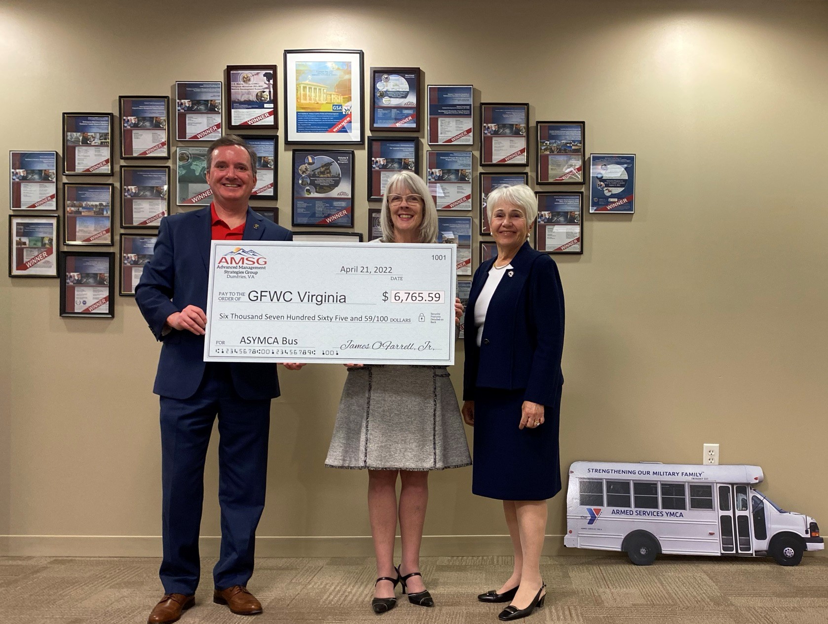 CEO holds large check for donation to GFWC