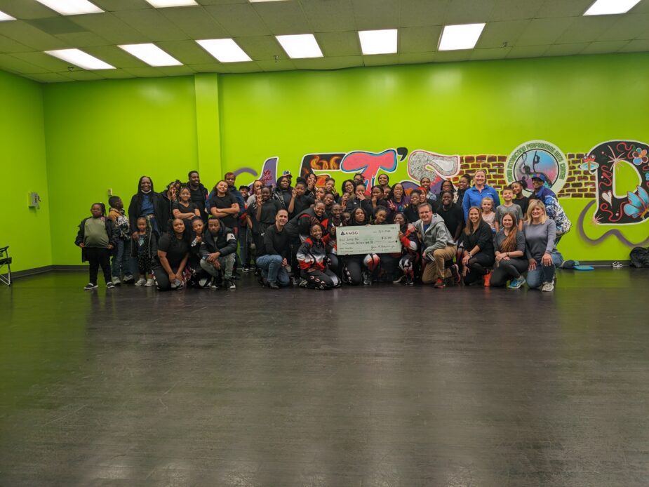 AMSG and Jump DC team picture with their donation check.
