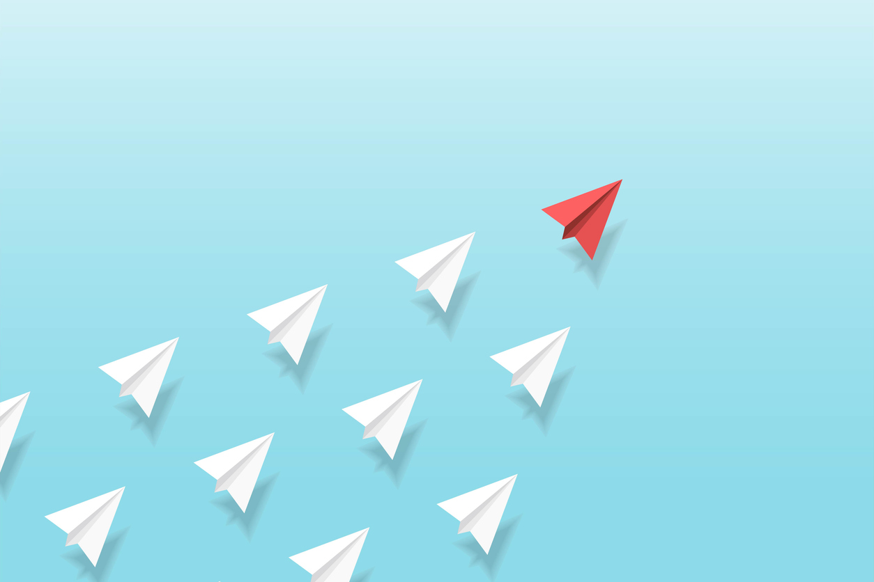 Paper airplane graphic: One red paper airplane leading a group of white paper airplanes flying diagonally upwards on a light blue background.